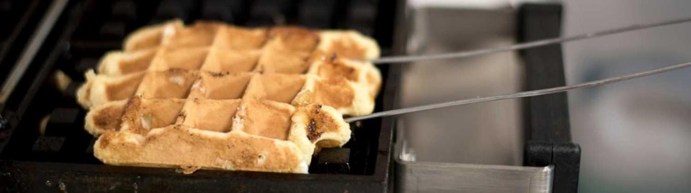 A waffle being cooked on a waffle grill