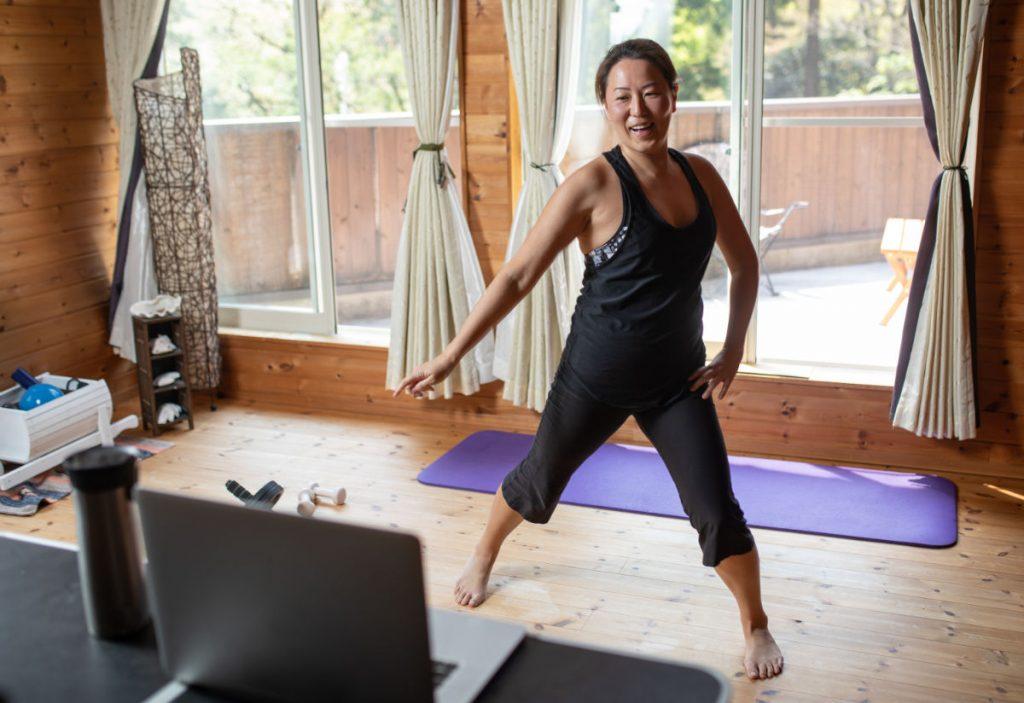 woman in yoga or zumba class looking at laptop
