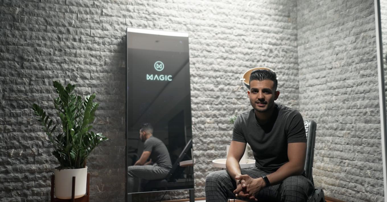 A man sitting in front of a mirror advertising the magic AI device