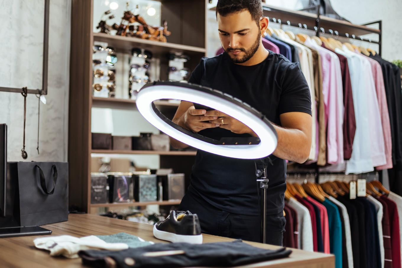 A photographer setting up to take images or vlog of their product beneath a lighting ring